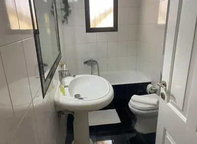 a white bathroom with a sink and a toilet at Modern Ease by the CoastFaliro 2Bed Gem in Athens