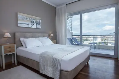 a bedroom with a large bed and a large window at Waves of Comfort Premium 3-Bd Stay in Alimos in Athens