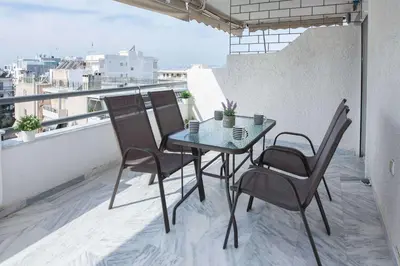 a table and chairs on a balcony with a view at Waves of Comfort Premium 3-Bd Stay in Alimos in Athens