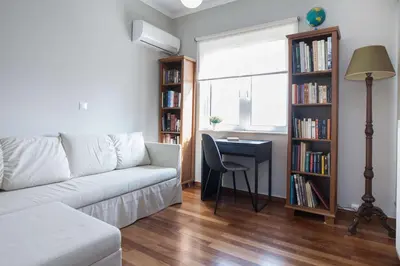 a living room with a couch and a table and a desk at Waves of Comfort Premium 3-Bd Stay in Alimos in Athens