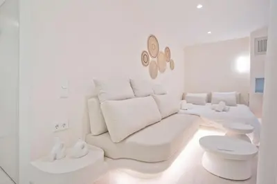 a white living room with a couch and a table at Radiant Voula Studio, a stone's throw from the Sea in Athens