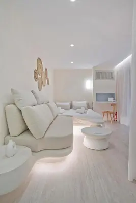 a white living room with a white couch and tables at Radiant Voula Studio, a stone's throw from the Sea in Athens