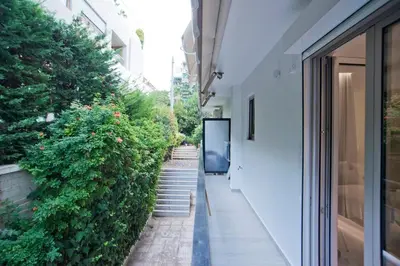 a hallway of a building with stairs and plants at Radiant Voula Studio, a stone's throw from the Sea in Athens