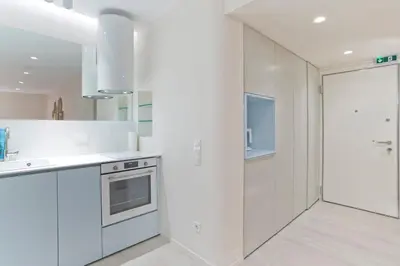 a white kitchen with a sink and a stove at Radiant Voula Studio, a stone's throw from the Sea in Athens