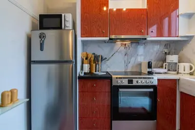 a kitchen with a stainless steel refrigerator and red cabinets at Noir Luxury 1 bedroom Atelier in Athens