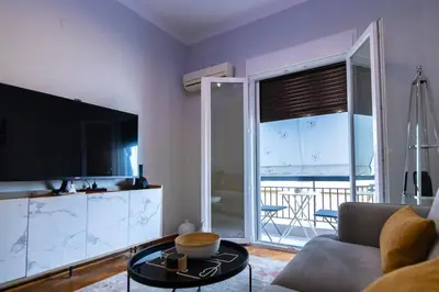 a living room with a couch and a tv and a table at Noir Luxury 1 bedroom Atelier in Athens
