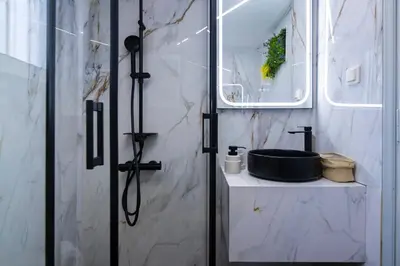 a bathroom with a shower with a black sink at Noir Luxury 1 bedroom Atelier in Athens