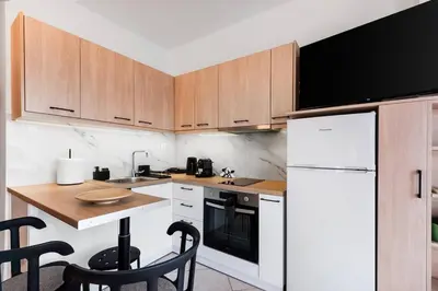 a kitchen with wooden cabinets and a white refrigerator at Elysian Lycabettus - Panorama in Athens