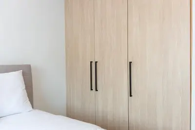 a bedroom with a wooden cabinet next to a bed at Elysian Lycabettus - Panorama in Athens