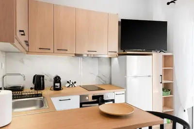 a small kitchen with a table and a tv at Elysian Lycabettus - Panorama in Athens