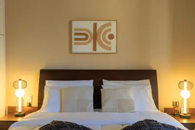 a bedroom with a bed with white sheets and two lamps at Aiolos Alimos Riviera super luxury Grand suite with gym in Athens
