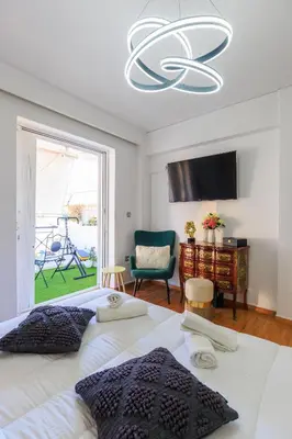 a bedroom with a large bed with a chandelier at Aiolos Alimos Riviera super luxury Grand suite with gym in Athens