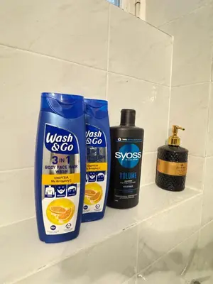 a shelf with two bottles of sunscreen and a bottle of cleaner at Aiolos Alimos Riviera super luxury Grand suite with gym in Athens