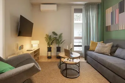 a living room with two couches and a table at Eclectic Studio near Kallimarmaro in Athens