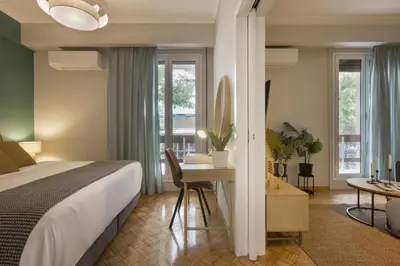 a bedroom with a bed and a desk with a table at Eclectic Studio near Kallimarmaro in Athens