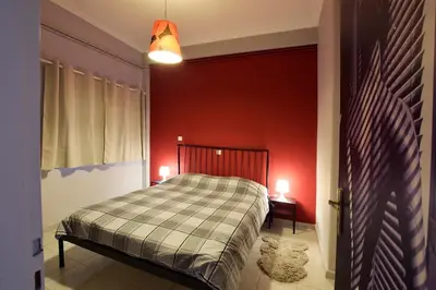 a bedroom with a bed and a red wall at Celia's in Athens