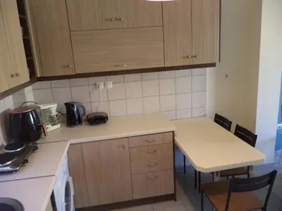 a kitchen with wooden cabinets and a white counter top at Celia's in Athens