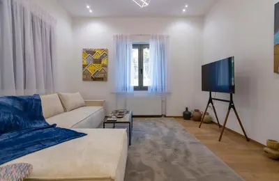 a living room with a couch and a flat screen tv at Timeless 1 bedroom Luxury at Panathenaic Stadium in Athens