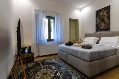 a bedroom with a bed and a couch and a window at Timeless 1 bedroom Luxury at Panathenaic Stadium in Athens