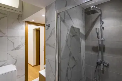 a bathroom with a shower with a glass door at Timeless 1 bedroom Luxury at Panathenaic Stadium in Athens