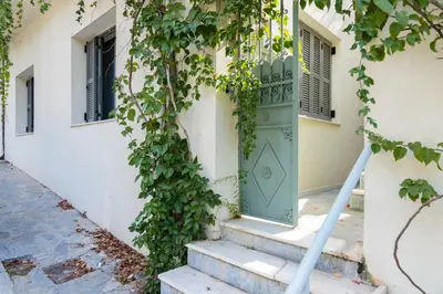 a green door with ivy on the side of a building at Timeless 1 bedroom Luxury at Panathenaic Stadium in Athens
