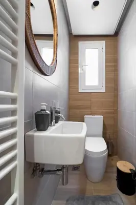 a bathroom with a sink and a toilet and a mirror at Zen Vouliagmeni Beach Apartment 2 in Athens