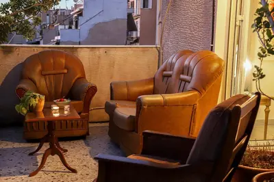 two leather chairs and a table on a balcony at Adorable Jacuzzi flat in the most alive Athens! in Athens