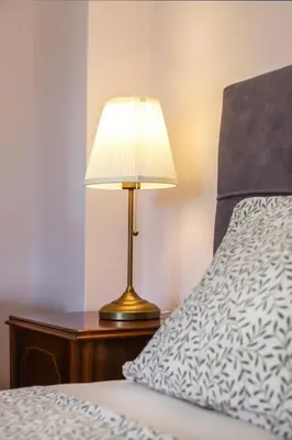 a lamp sitting on a table next to a bed at Adorable Jacuzzi flat in the most alive Athens! in Athens