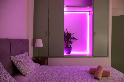 a bedroom with a purple light in a window at Adorable Jacuzzi flat in the most alive Athens! in Athens