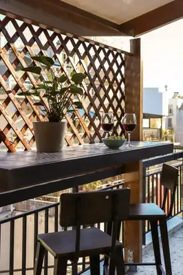 a table with two glasses of wine and a plant on a balcony at Adorable Jacuzzi flat in the most alive Athens! in Athens