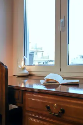 an open book on a wooden desk with a window at Adorable Jacuzzi flat in the most alive Athens! in Athens