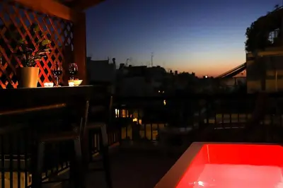 a red tub on a balcony with a view of a city at Adorable Jacuzzi flat in the most alive Athens! in Athens