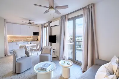 a living room with a couch and chairs and a kitchen at Penthouse in the heart of Athens in Athens