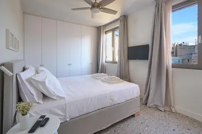 a white bedroom with a bed and a window at Penthouse in the heart of Athens in Athens