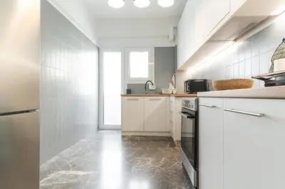 a kitchen with white cabinets and a sink at Elegant 3 Bdr Apartment City Retreat in Kypseli in Mesochórion