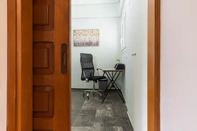 a room with a desk and a chair next to a door at Elegant 3 Bdr Apartment City Retreat in Kypseli in Mesochórion