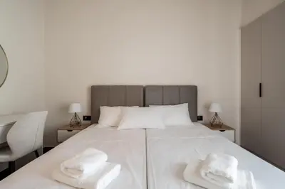a bedroom with a large white bed with two white towels at Stylish 2-Lvl maisonette near to Acropolis Museum in Athens