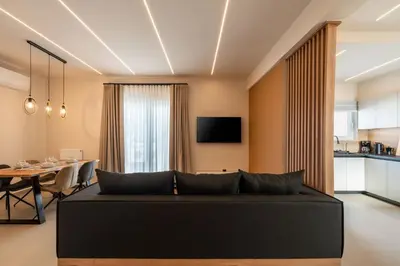 a living room with a black couch and a table at Stylish 2-Lvl maisonette near to Acropolis Museum in Athens