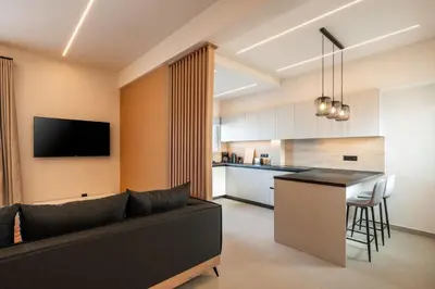 a living room with a couch and a kitchen at Stylish 2-Lvl maisonette near to Acropolis Museum in Athens
