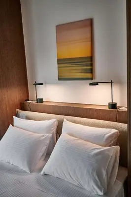 a bedroom with three beds and a painting on the wall at By the Ellinikon in Athens