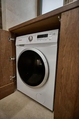 a white washing machine sitting in a cabinet at By the Ellinikon in Athens
