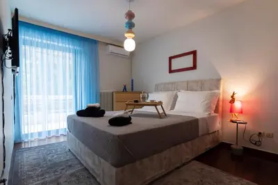 a bedroom with a large bed and a large window at Blue Verve Premium 2 bedroom Retreat in Athens