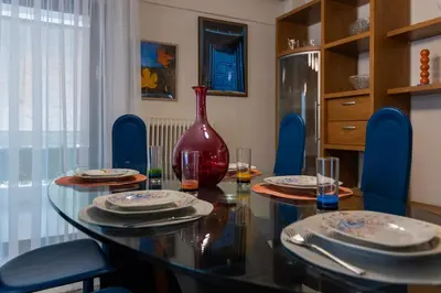 a dining room with a glass table and a vase at Blue Verve Premium 2 bedroom Retreat in Athens