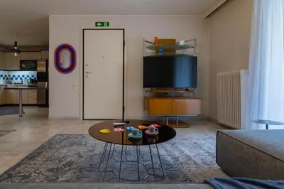 a living room with a table and a tv at Blue Verve Premium 2 bedroom Retreat in Athens