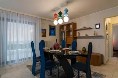 a dining room with a table and blue chairs at Blue Verve Premium 2 bedroom Retreat in Athens