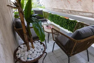 a patio with chairs and a plant on a balcony at Blue Verve Premium 2 bedroom Retreat in Athens