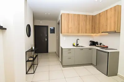a kitchen with wooden cabinets and a white tile floor at Omonia Flow One by ΜΡS in Athens