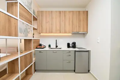 a kitchen with wooden cabinets and a stainless steel refrigerator at Omonia Flow Two by ΜΡS in Athens