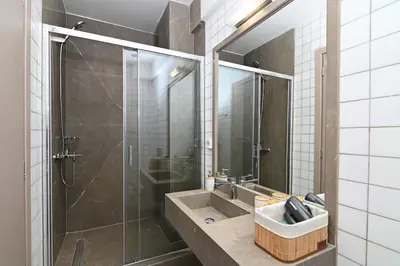 a bathroom with a sink and a glass shower at Omonia Flow Two by ΜΡS in Athens