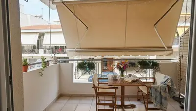 a balcony with a table and chairs in a room at The Calm Corner of Ampelokipoi in Athens